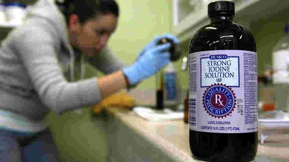 A worker at West Marin Pharmacy, Point Reyes, Calif., fills vials with strong iodine solution on Tuesday.
