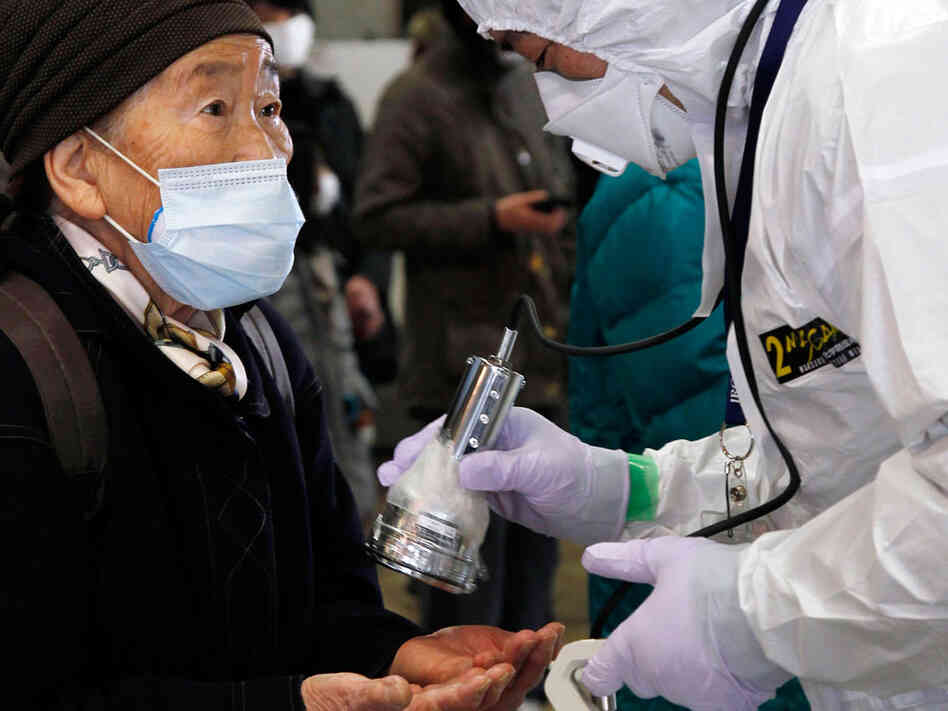 An official in a full radiation protection suit scans an evacuated elderly woman (L) with a geiger counter to check radiation levels in Koriyama city in Fukushima prefecture, about 60km west from the crisis-hit Tokyo Electric Power Co (TEPCO) Fukushima Nuclear plant, on March 16, 2011. An official in a full radiation protection suit scans an evacuated elderly woman (L) with a geiger counter to check radiation levels in Koriyama city in Fukushima prefecture, about 60km west from the crisis-hit Tokyo Electric Power Co (TEPCO) Fukushima Nuclear plant, on March 16, 2011.