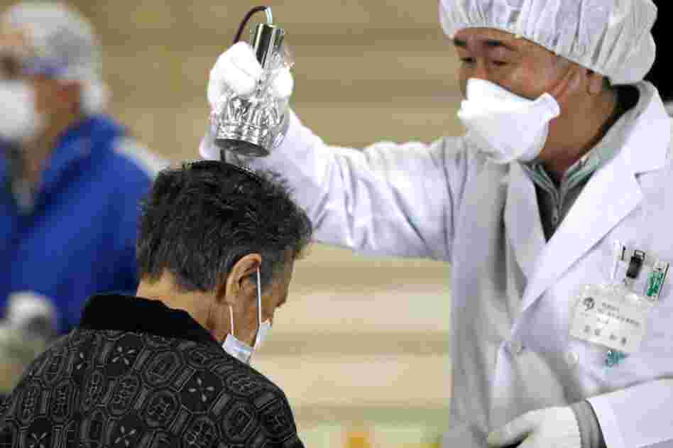 An elderly woman is scanned for radiation screening center in Koriyama, Fukushima prefecture. 