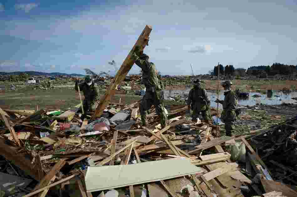 Japanese soldiers comb through the rubble of a destroyed building in the city of Kesennuma, Miyagi prefecture. 
