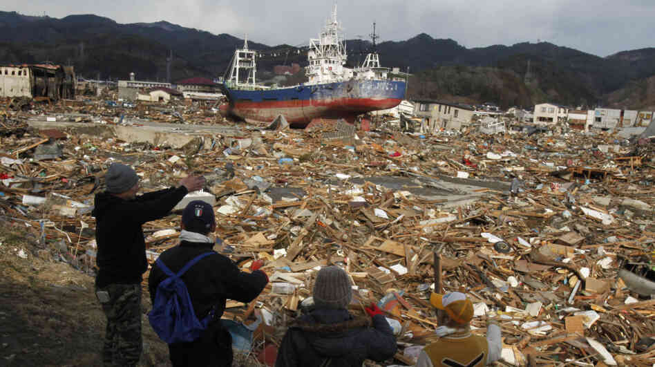 Survivors overlook the earthquake and tsunami-hit area in Kesennuma, Miyagi prefecture, Japan, on Thursday. Survivors overlook the earthquake and tsunami-hit area in Kesennuma, Miyagi prefecture, Japan, on Thursday.