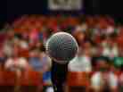 A microphone in front of an audience. A microphone in front of an audience.