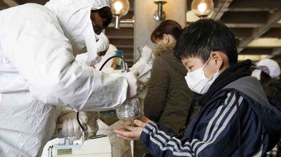 A boy evacuated from Koriyama, some 37 miles from the Fukushima Dai-ichi plant, gets scanned with a Geiger counter Wednesday.