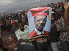 Supporters of Haiti's ousted President Jean-Bertrand Aristide hold up a poster of the exiled leader in Port-au-Prince, Haiti, Thursday March 17, 2011. Supporters of Haiti's ousted President Jean-Bertrand Aristide hold up a poster of the exiled leader in Port-au-Prince, Haiti, Thursday March 17, 2011.