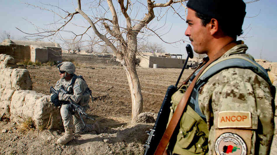 An Afghan police officer (right) stands near a U.S. soldier in the Panjwai district of Kandahar province, Afghanistan, on Dec. 8. An Afghan police officer (right) stands near a U.S. soldier in the Panjwai district of Kandahar province, Afghanistan, on Dec. 8.