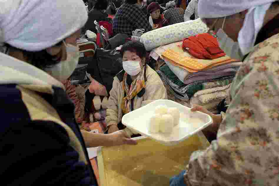 A woman waits for rice at an evacuation center in Rikuzentakata. 