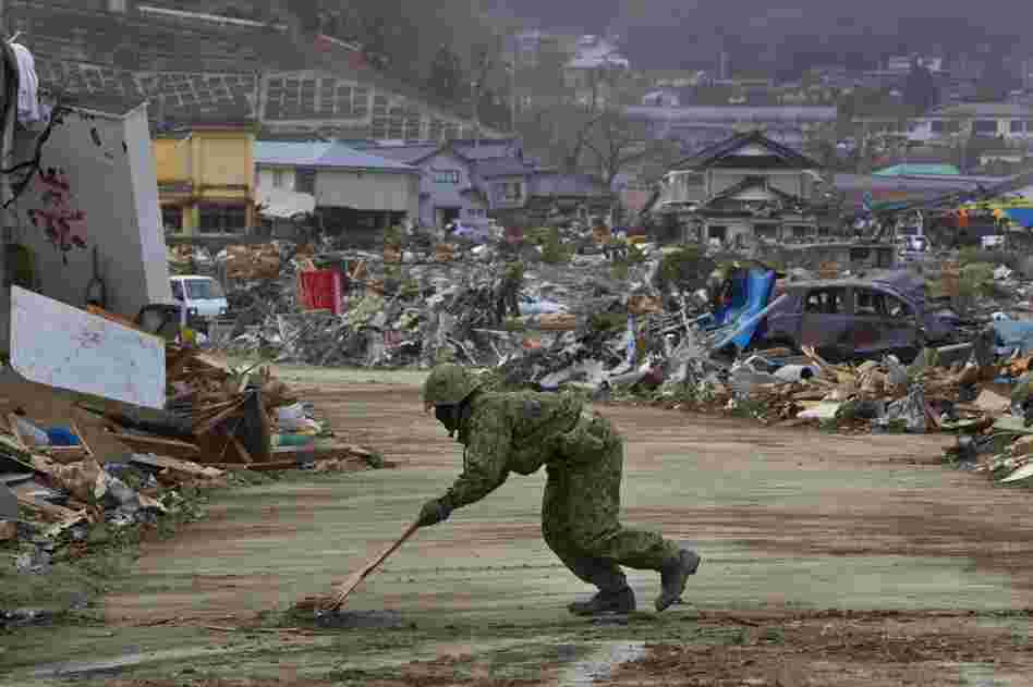 A member of the Japanese military clears a road to allow cranes and bulldozers into Ofunato. 