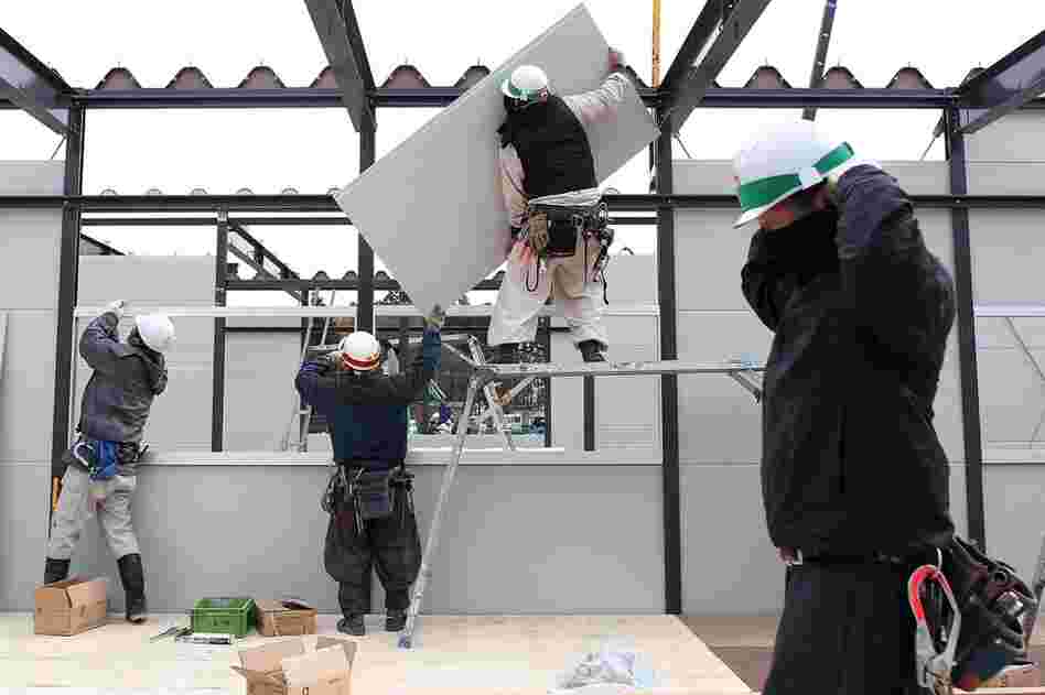 Construction workers build temporary housing in Rikuzentakata. 