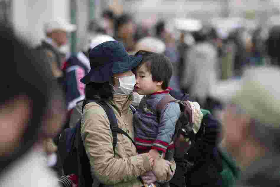 A woman and baby wait to buy food at a supermarket in Sendai, Miyagi prefecture. 