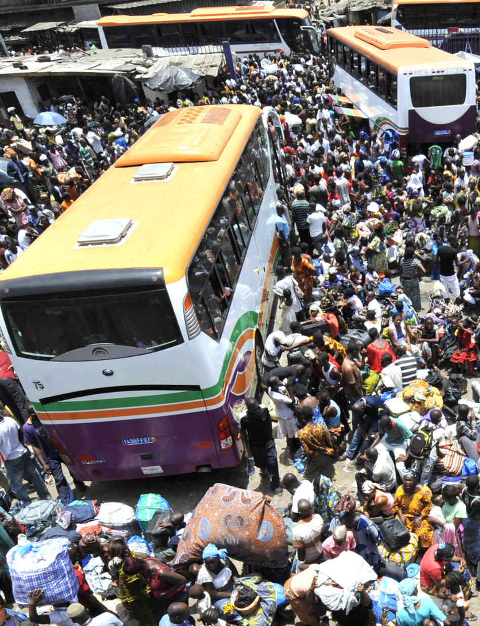 Residents of Abidjan wait for buses Saturday to flee increasing violence in Ivory Coast. Residents of Abidjan wait for buses Saturday to flee increasing violence in Ivory Coast.