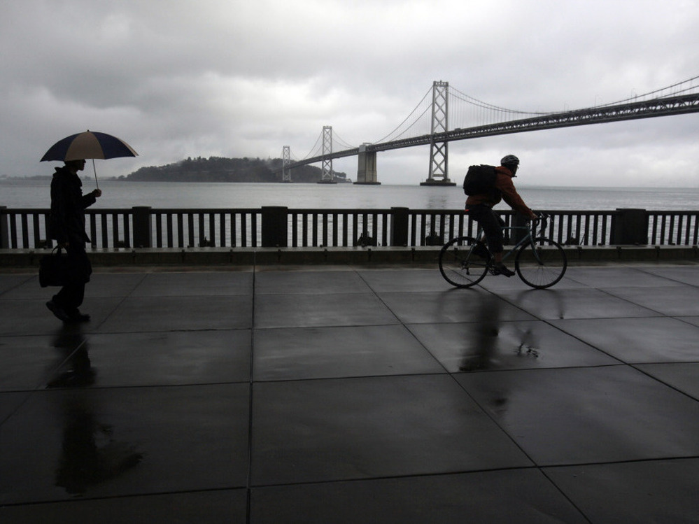 A pedestrian and cyclist are seen along the Embarcadero with the San Francisco Oakland Bay Bridge in the background. San Francisco dismantled a freeway in this location in the early 1990s. A pedestrian and cyclist are seen along the Embarcadero with the San Francisco Oakland Bay Bridge in the background. San Francisco dismantled a freeway in this location in the early 1990s.