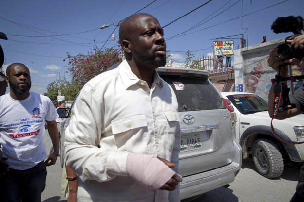 With a bandage in his right hand, Haitian-American singer Wyclef Jean, leaves a polling station after casting his ballot during a presidential runoff in Port-au-Prince, Haiti.