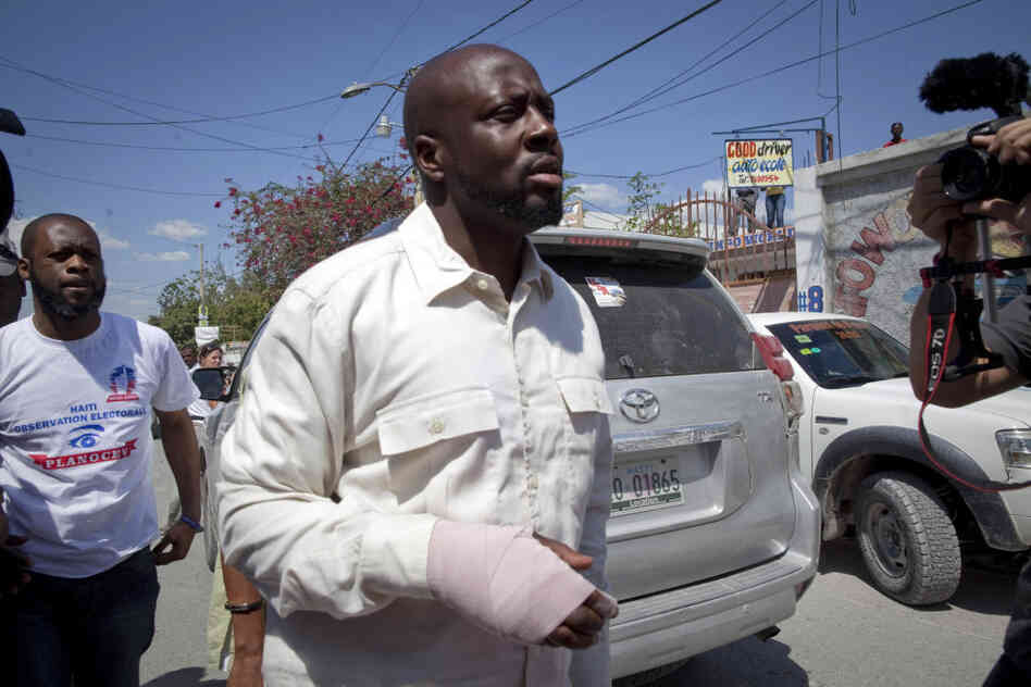 With a bandage in his right hand, Haitian-American singer Wyclef Jean, leaves a polling station after casting his ballot during a presidential runoff in Port-au-Prince, Haiti.