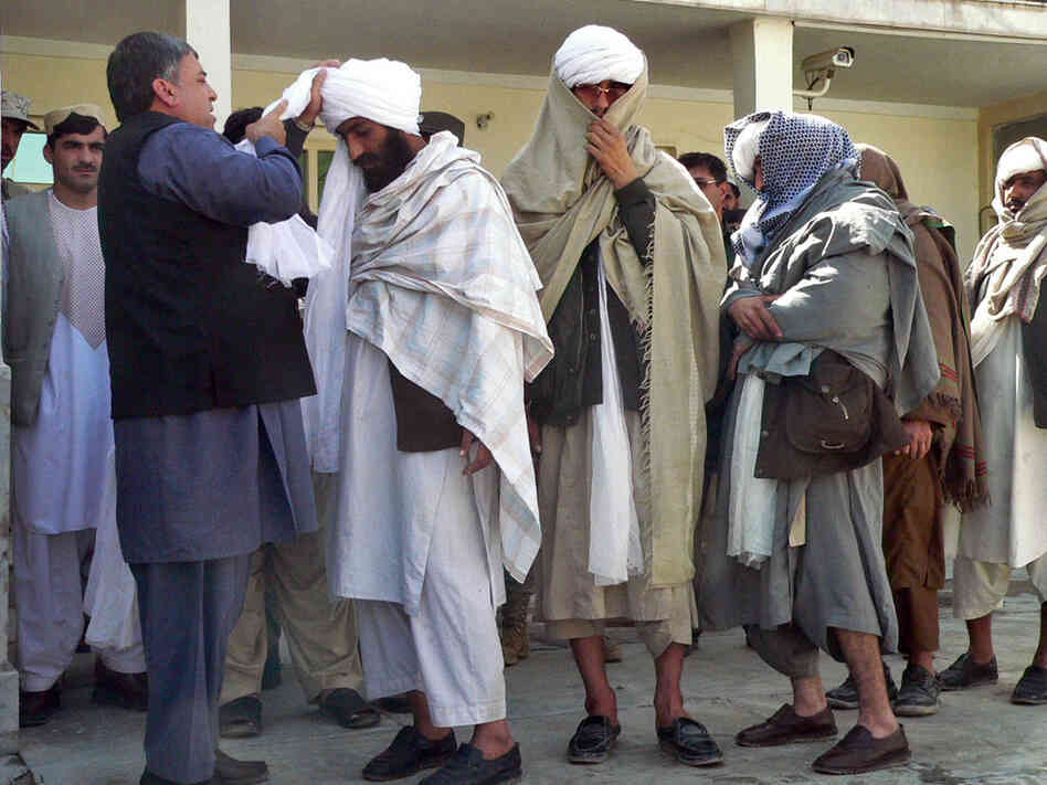 Kandahar Gov. Tooryalai Wesa, left, puts a turban on former Taliban fighter Malawi Azizullah. Kandahar Gov. Tooryalai Wesa, left, puts a turban on former Taliban fighter Malawi Azizullah.