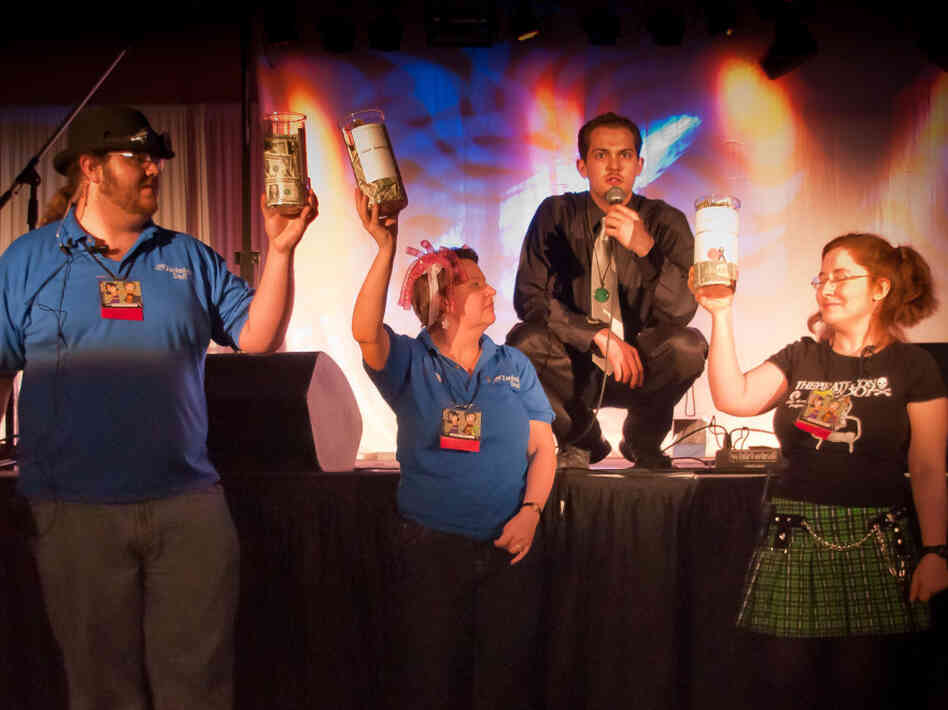 Zenkaikon staff members Brian Harkless (left), Colette Fozard and Matilda  Madden (right), collecting donations for Japanese tsunami victims. Comedian Karl  "Uncle Yo" Custer emcees at center.