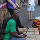 Percussionists Gidi Agbeko (green shirt) and Sam Bathrick (purple shirt) play on the street at SXSW in Austin on March 18, 2011.