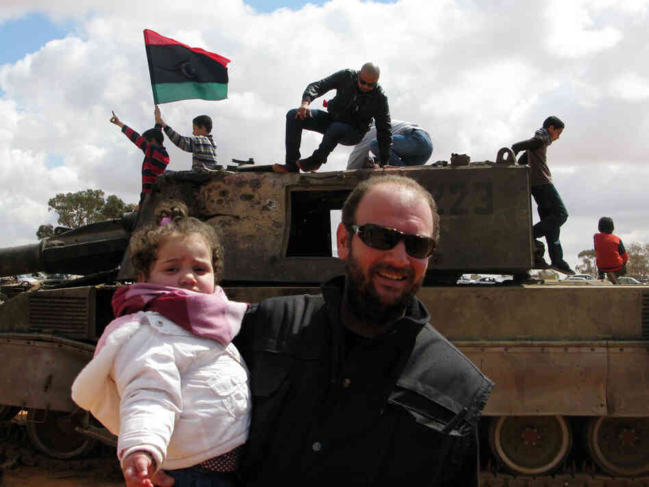 Ahmed Jarbou, 45, a businessman from Benghazi, and his 2-year-old daughter, Jude, examine remnants of destroyed mobile artillery from pro-Gadhafi forces. Ahmed Jarbou, 45, a businessman from Benghazi, and his 2-year-old daughter, Jude, examine remnants of destroyed mobile artillery from pro-Gadhafi forces.