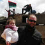 Ahmed Jarbou, 45, a businessman from Benghazi, and his 2-year-old daughter, Jude, examine remnants of destroyed mobile artillery from pro-Gadhafi forces. Ahmed Jarbou, 45, a businessman from Benghazi, and his 2-year-old daughter, Jude, examine remnants of destroyed mobile artillery from pro-Gadhafi forces.