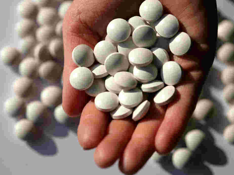 Pills in the palm of a woman's hand.