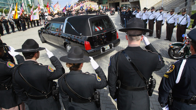 Police officers salute as a hearse carrying the body of one of two slain Miami-Dade police officers arrives for a memorial service in Miami in January. Officers Amanda Haworth and Roger Castillo were killed while serving an arrest warrant.