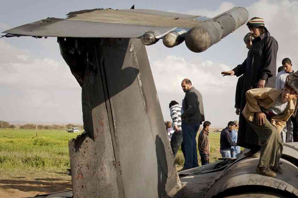 Libyans inspect the wreckage of a US  F-15 fighter jet after it crashed in an open field 25 miles southwest of the eastern rebel stronghold of Benghazi, Libya's second-largest city. 