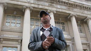 Herman Rainey, the Safe Passage coordinator for Leave No Veteran Behind, waits outside Chicago's Hyde Park Academy High School just before dismissal time.