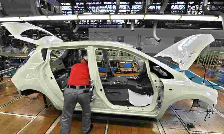 A worker assembles a Nissan Leaf electric vehicle at the company's Oppama plant in Yokosuka, Japan. Auto plants are reopening, but getting parts remains a challenge.