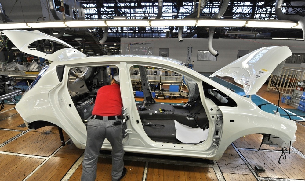 A worker assembles a Nissan Leaf electric vehicle at the company's Oppama plant in Yokosuka, Japan. Auto plants are reopening, but getting parts remains a challenge.