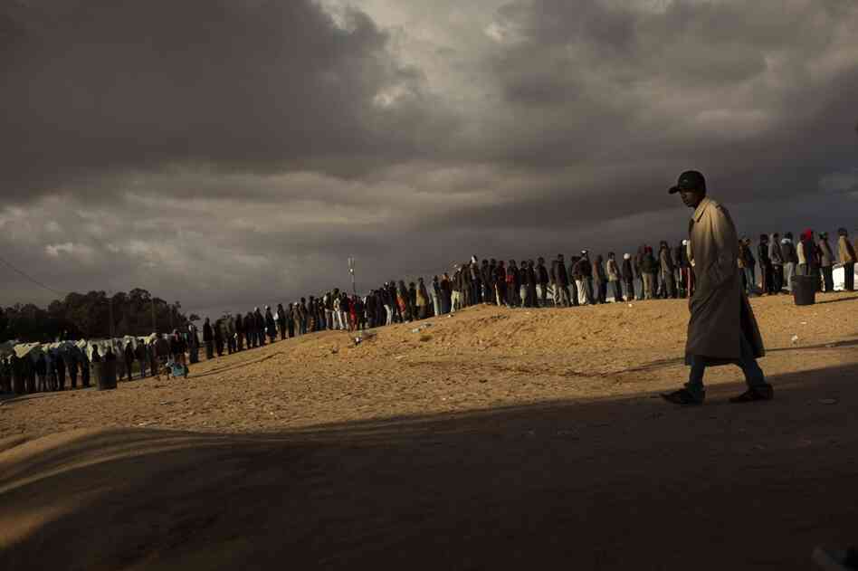 Men who used to work in Libya and fled the unrest in the country line up as they wait for food in a refugee camp in Ras Ajdir, Tunisia, on the Libyan border.  