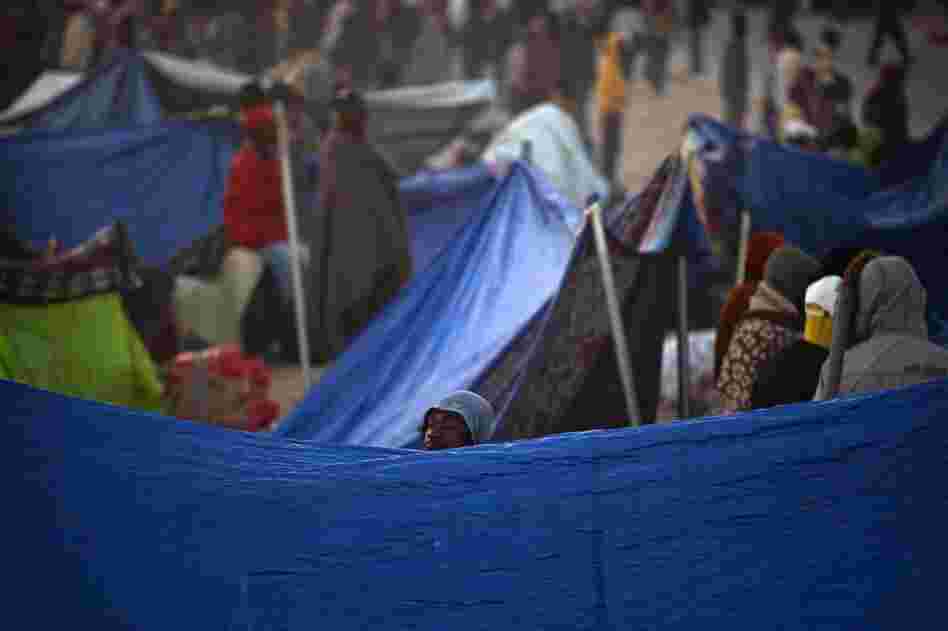 Workers who fled Libya are seen next to their makeshift shelters as they wait to be repatriated in a refugee camp in Ras Ajdir at the Tunisia-Libya border.  