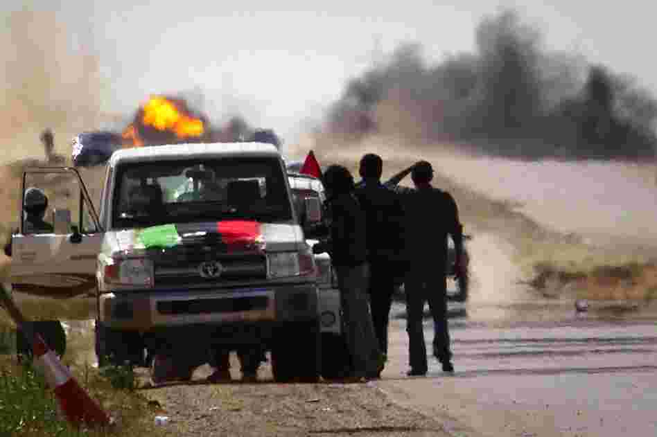 Libyan rebels stop on the road as mortars from Gadhafi's forces are fired on them outside Ajdabiya. 