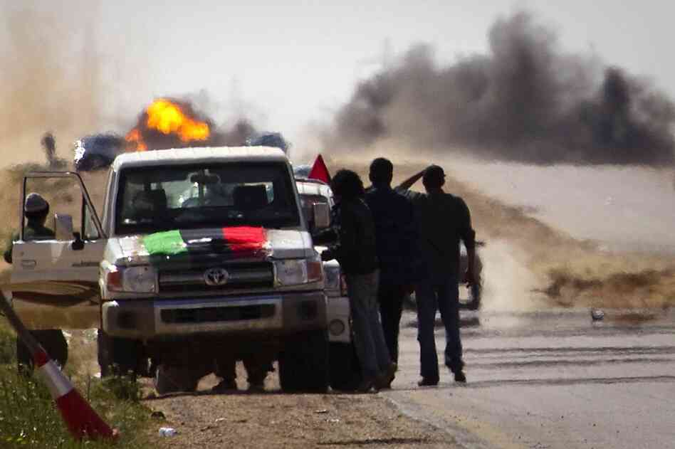 Libyan rebels stop on the road as mortars from Gadhafi's forces are fired on them outside Ajdabiya. 