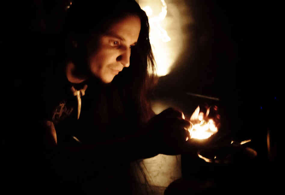 Guitarist and vocalist John Haughm lights incense at the front of the stage.