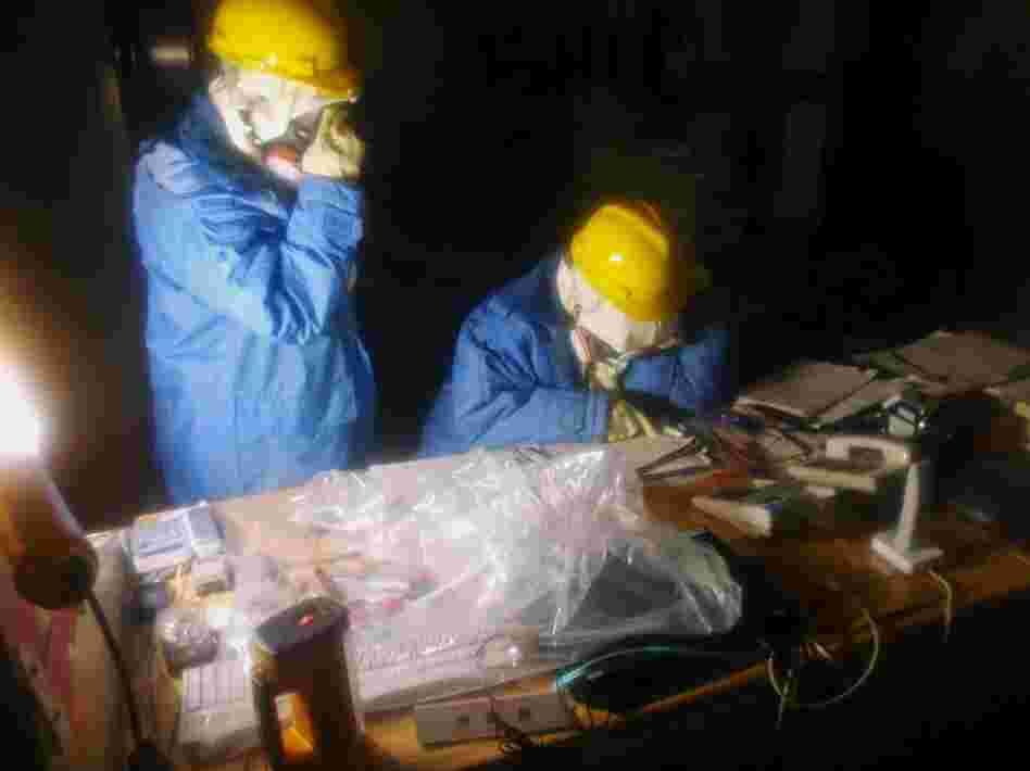 Workers collect data as part of an effort to repair a damaged reactor. Workers collect data as part of an effort to repair a damaged reactor.