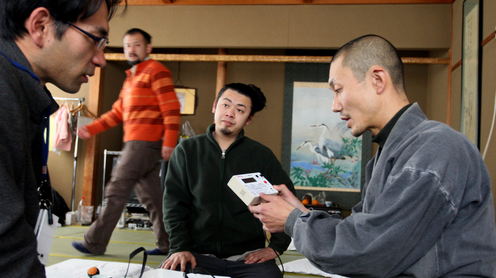 Japanese Buddhist monk Tanaka Tokuun, who was evacuated from Fukushima prefecture, looks over an instrument  measuring radiation levels at a hotel on March 17.