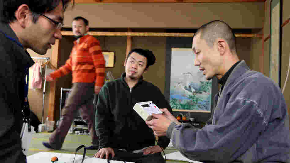Japanese Buddhist monk Tanaka Tokuun, who was evacuated from Fukushima prefecture, looks over an instrument  measuring radiation levels at a hotel on March 17.