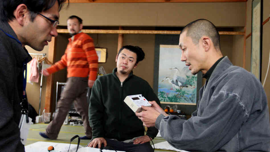 Japanese Buddhist monk Tanaka Tokuun, who was evacuated from Fukushima prefecture, looks over an instrument  measuring radiation levels at a hotel on March 17.