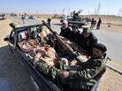 Libyan rebels rest in a pick-up truck near Ajdabiya, Libya on March 23, 2011 as government forces encircled the town.