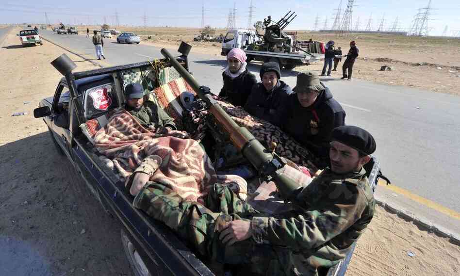 Libyan rebels rest in a pick-up truck near Ajdabiya, Libya on March 23, 2011 as government forces encircled the town.