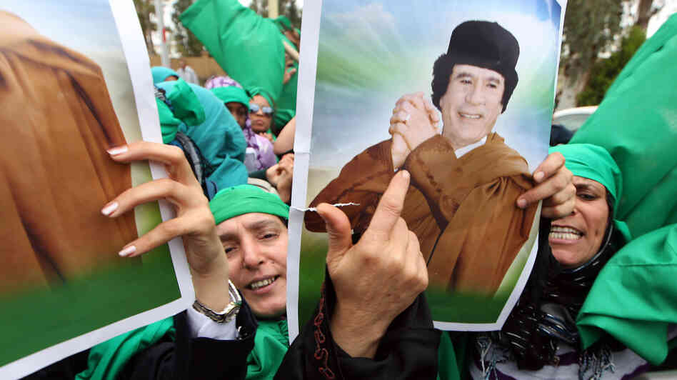 Libyan women hold pictures of leader Moammar Gadhafi in Tripoli earlier this month during a protest against the U.N. resolution authorizing a no-fly zone. The government, says NPR's David Greene, wants Tripoli to seem like a place full of people who revere Gadhafi. There are signs, however, that Gadhafi's grip on the capital could be loosening. Libyan women hold pictures of leader Moammar Gadhafi in Tripoli earlier this month during a protest against the U.N. resolution authorizing a no-fly zone. The government, says NPR's David Greene, wants Tripoli to seem like a place full of people who revere Gadhafi. There are signs, however, that Gadhafi's grip on the capital could be loosening.