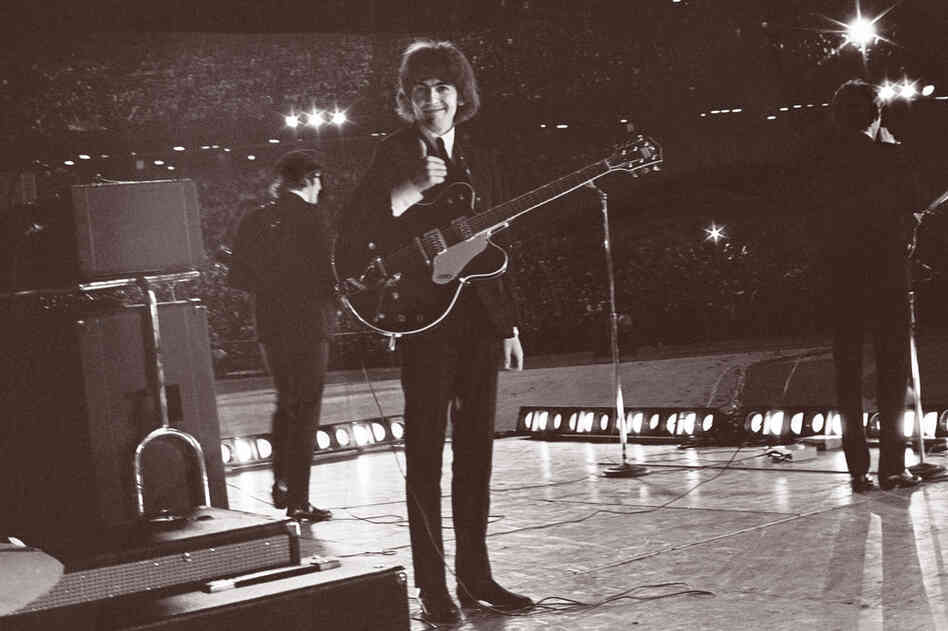 From the stage at Metropolitan Stadium in Bloomington, Minn., George Harrison turns to see Bob Bonis with his camera and gives him a thumbs up. Aug. 21, 1965.
