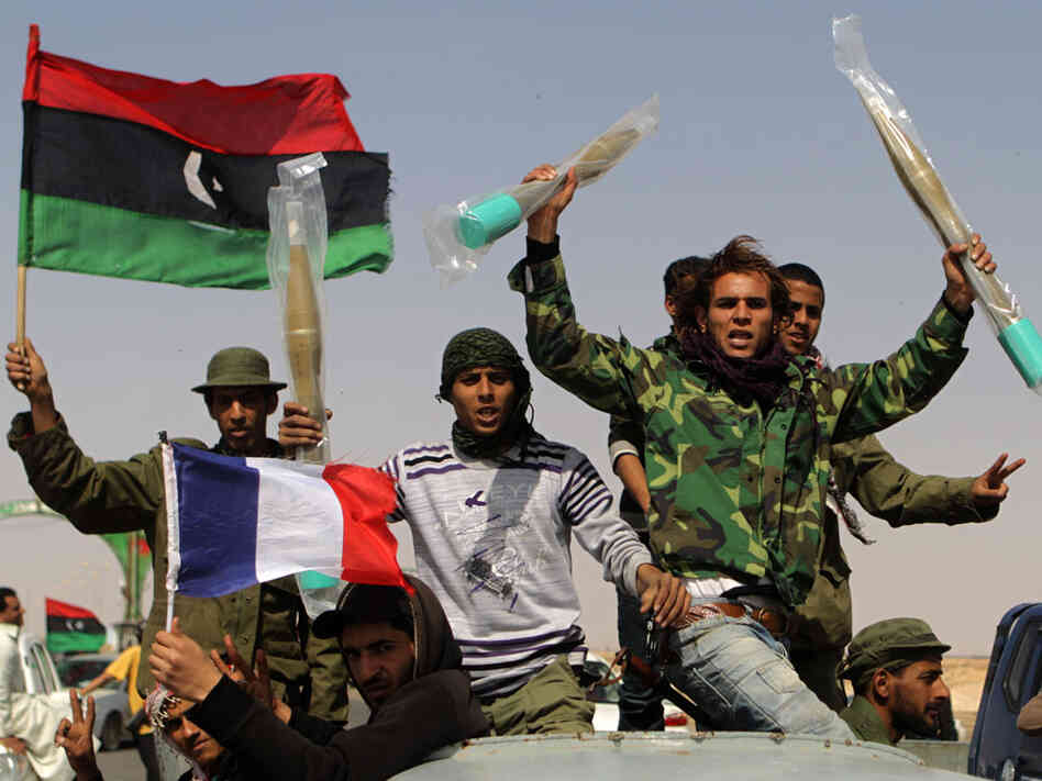 Libyan rebels, waving the French and rebellion flags, raise brand new rocket propeled grenades they took from abandonned pro-government forces ammunitions stocks on March 27, 2011 in Ajdabiya. Libyan rebels, waving the French and rebellion flags, raise brand new rocket propeled grenades they took from abandonned pro-government forces ammunitions stocks on March 27, 2011 in Ajdabiya.