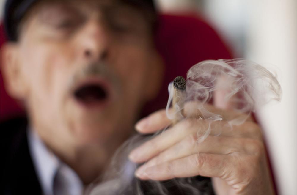 Moshe Rute smokes marijuana at the Hadarim nursing home in Kibutz Naan, Israel, in early March. The Israeli government and a private company are distributing cannabis for medicinal purposes to more than 1,800 people in Israel.