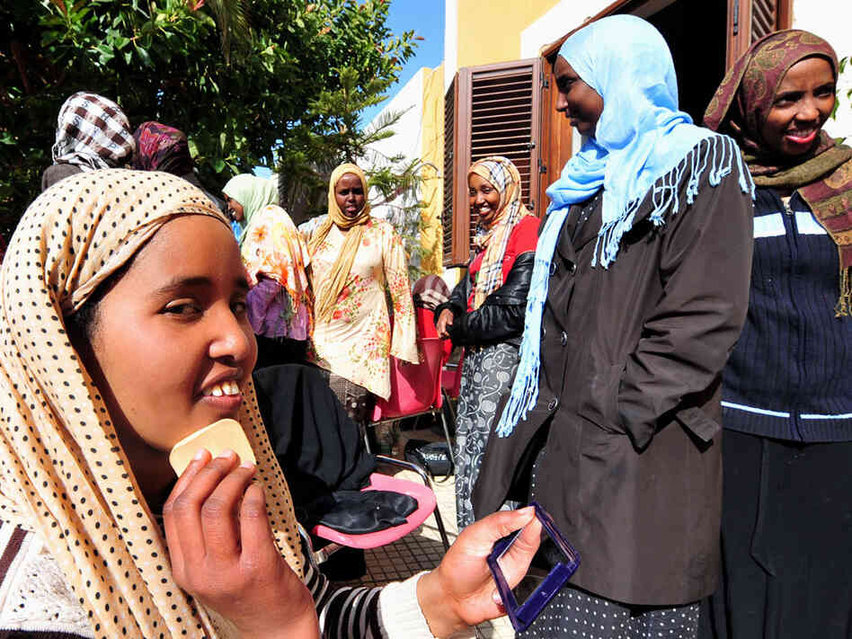 A young African woman who fled Libya puts on makeup as she rests with other female refugees Monday on the tiny Italian island of Linosa. A young African woman who fled Libya puts on makeup as she rests with other female refugees Monday on the tiny Italian island of Linosa.