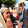 A young  African woman who fled Libya puts on makeup as she rests with other female refugees Monday on the tiny Italian island of  Linosa.