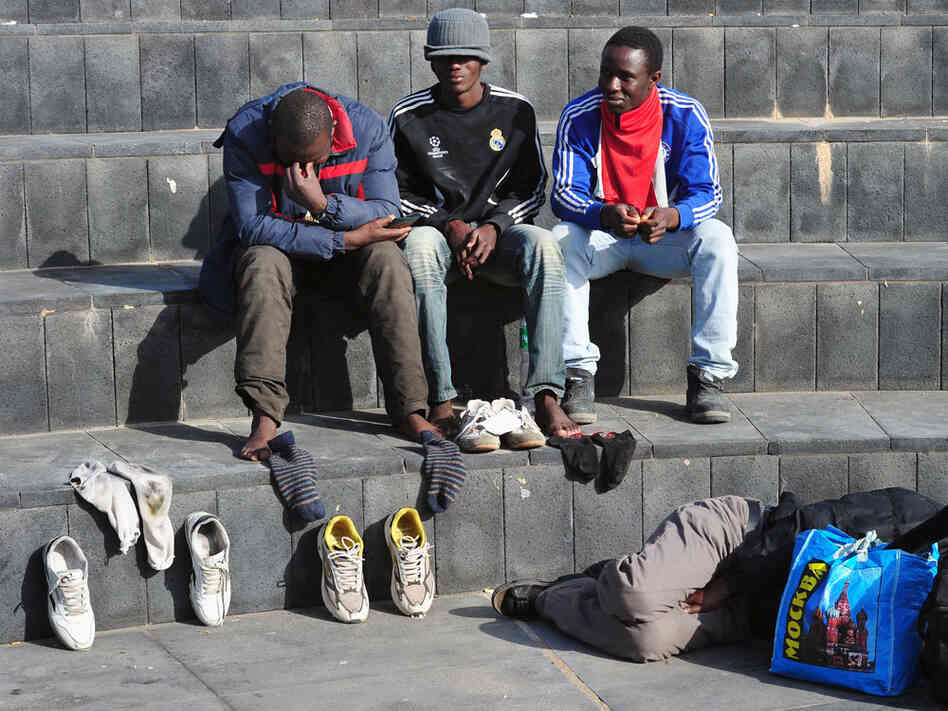 African refugees rest near Linosa's port. African refugees rest near Linosa's port.