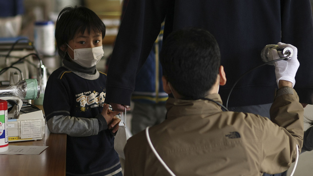 Earlier today (March 29, 2011), a boy watched his father being screened for radiation at a shelter in Fukushima prefecture.