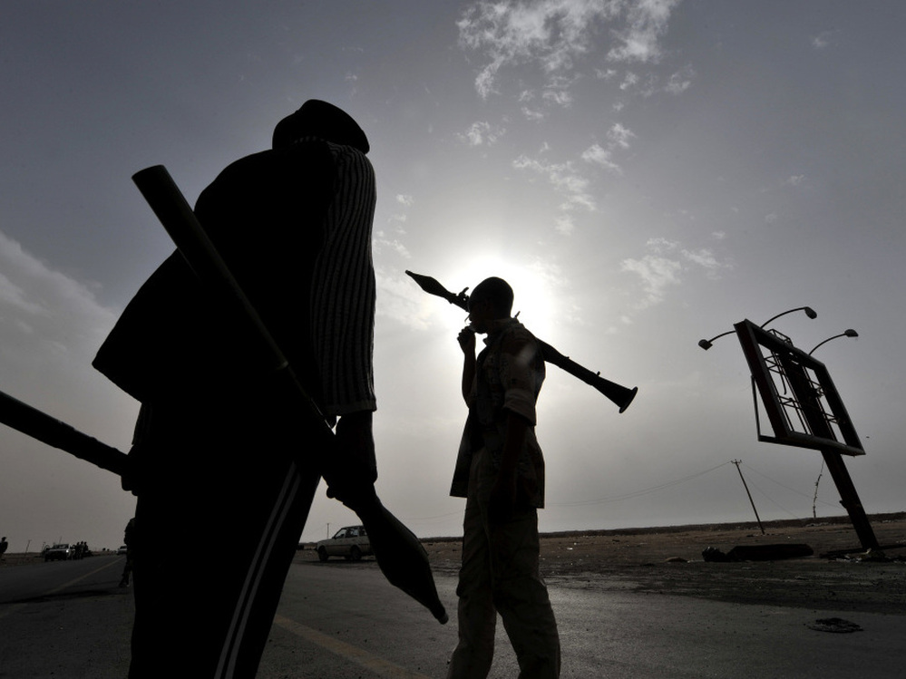 Libyan rebels carry rocket-propelled grenades as they take position at the west gate of the eastern city of Ajdabiya on Wednesday.