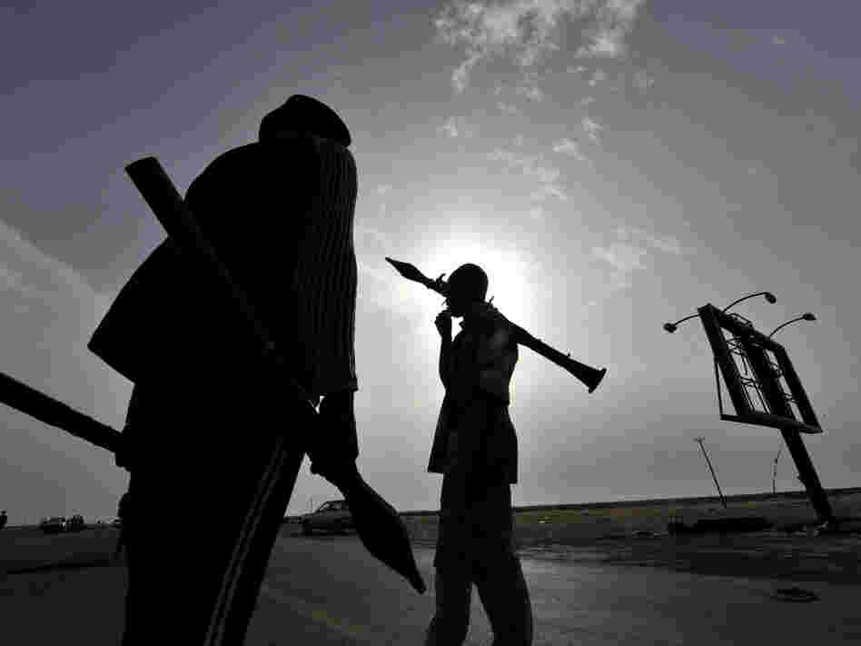 Libyan rebels carry rocket-propelled grenades as they take position at the west gate of the eastern city of Ajdabiya on Wednesday.