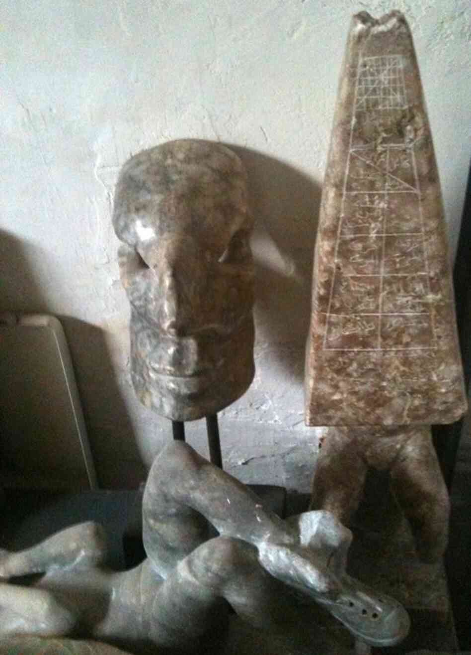 Khalil often uses martial themes, like the army boots on this figure in repose, and the otherworldly helmet-like figure at left. 